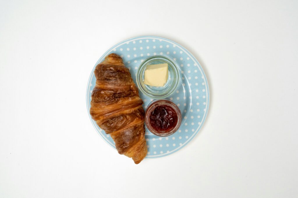 Croissant on plate with butter.